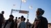 Afghan men stand near the Afghanistan-Iran border crossing of Islam Qala, on Nov. 24, 2021.