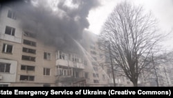 Firefighters spray water an apartment building following a Russian air attack on the Ukrainian city of Sumy on March 24.